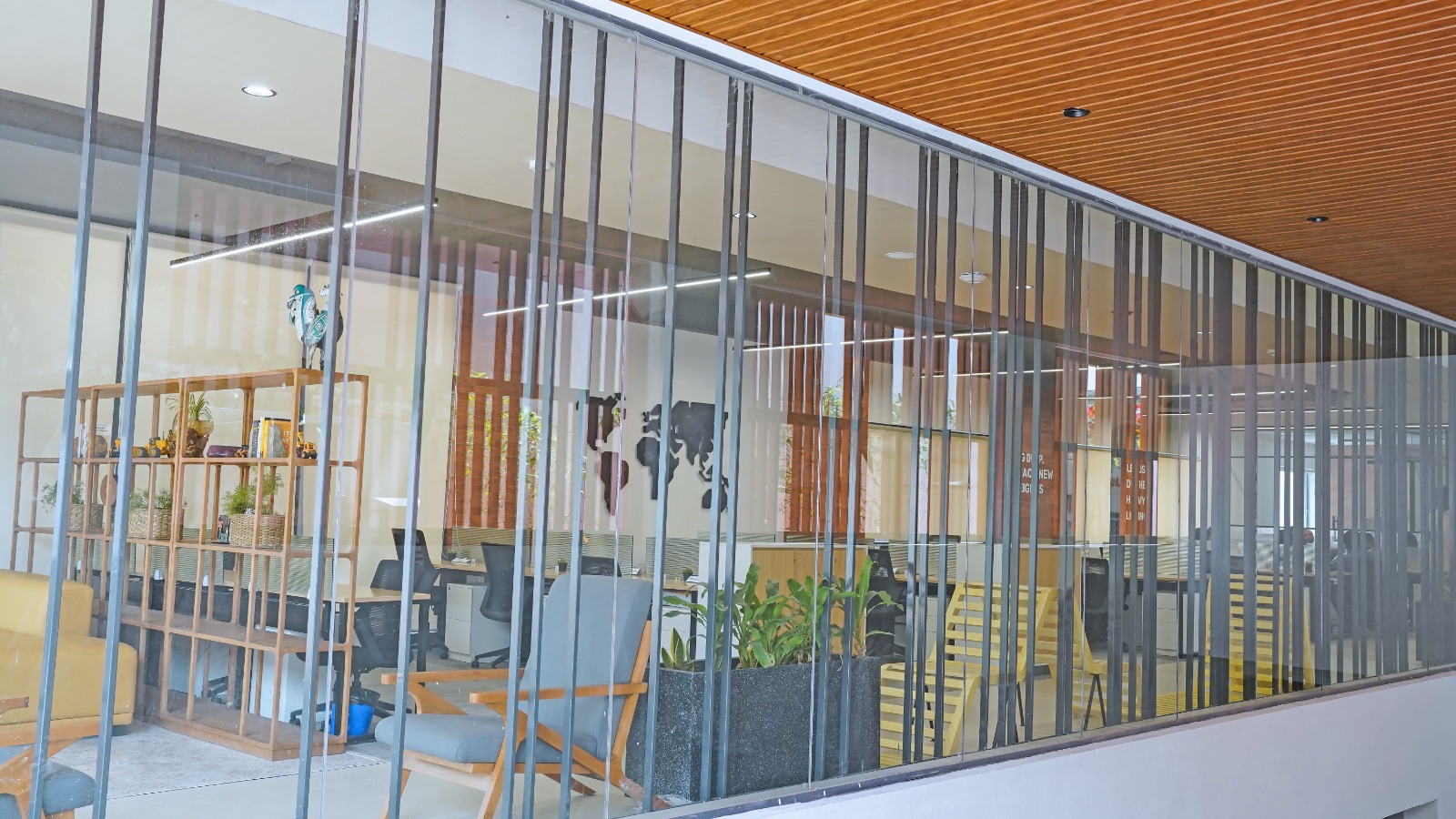 Glass façade and wood-slat ceiling at the entrance to the Ground Floor office space at Capstone House, 1 km from MG Road Metro Bangalore